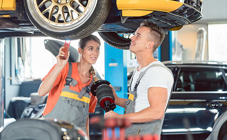female mechanic - Experienced female auto mechanic checking tires before installing together with her colleague a new air suspension system in a modern automobile repair shop Foto de stock - Super Valor sin royalties y Suscripción, Código: 400-09222450