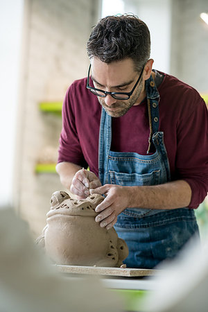 pottery sculpt - Ceramist Dressed in an Apron Sculpting Statue from Raw Clay in the Bright Ceramic Workshop. Stock Photo - Budget Royalty-Free & Subscription, Code: 400-09222534