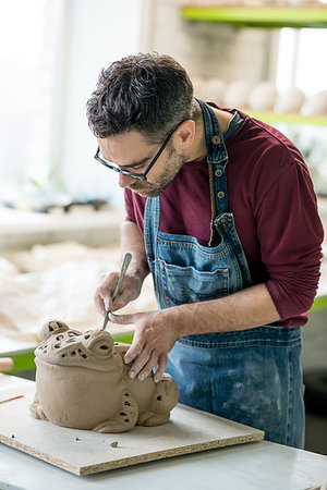 pottery sculpt - Ceramist Dressed in an Apron Sculpting Statue from Raw Clay in the Bright Ceramic Workshop. Stock Photo - Budget Royalty-Free & Subscription, Code: 400-09222538