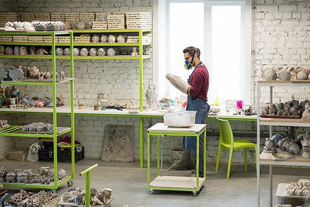 pottery sculpt - Portrait of Ceramist Dressed in an Apron Working on Clay Sculpture in the Bright Ceramic Workshop. Stock Photo - Budget Royalty-Free & Subscription, Code: 400-09222547