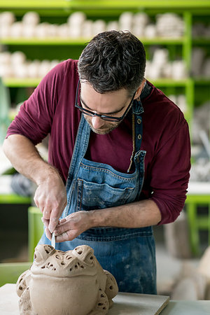 pottery sculpt - Ceramist Dressed in an Apron Sculpting Statue from Raw Clay in the Bright Ceramic Workshop. Stock Photo - Budget Royalty-Free & Subscription, Code: 400-09222540