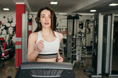 Young pretty girl is trained in the gym. Running on a treadmill in the gym Foto de stock - Super Valor sin royalties y Suscripción, Código: 400-09222581