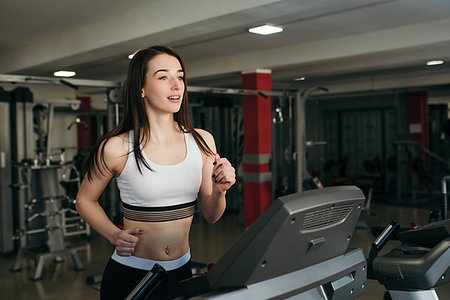 Young pretty girl is trained in the gym. Running on a treadmill in the gym Foto de stock - Super Valor sin royalties y Suscripción, Código: 400-09222582