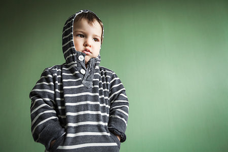 Sad cute small boy holding hands in pullover pockets.Free space for advertisement Stock Photo - Budget Royalty-Free & Subscription, Code: 400-09222654