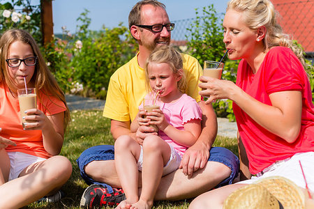 Happy family having picnic in garden front of their home Photographie de stock - Aubaine LD & Abonnement, Code: 400-09222885