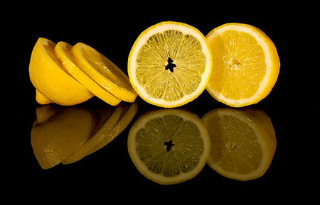 View of macro still life - cut lemon on black background with reflection Foto de stock - Royalty-Free Super Valor e Assinatura, Número: 400-09222978