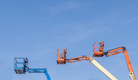 Three Cherry Picker machines against a blue sky Stock Photo - Budget Royalty-Free & Subscription, Code: 400-09222997