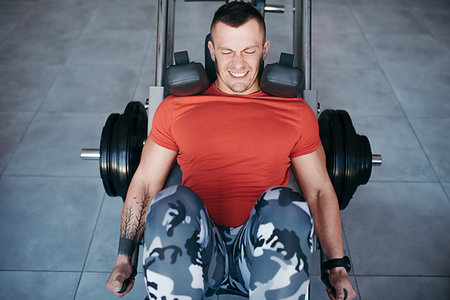 simsearch:400-06914161,k - Fit man training legs on leg press machine in the gym. Sport activities Photographie de stock - Aubaine LD & Abonnement, Code: 400-09223214