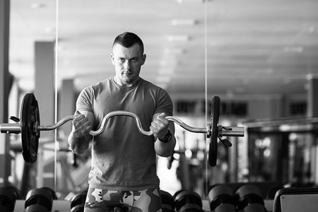 Fit young man lifting barbells looking focused, working out in a gym with other people. Sport activities Foto de stock - Super Valor sin royalties y Suscripción, Código: 400-09223213