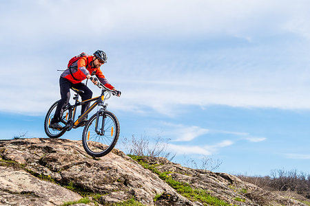 simsearch:400-08298519,k - Cyclist in Red Jacket Riding the Mountain Bike Down Rocky Hill. Extreme Sport and Adventure Concept. Photographie de stock - Aubaine LD & Abonnement, Code: 400-09223603
