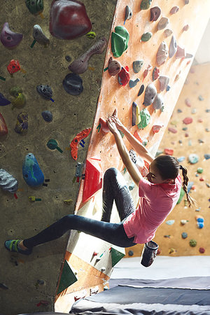 woman climber climbs indoors in bouldering gym with dramatic light Fotografie stock - Microstock e Abbonamento, Codice: 400-09223663