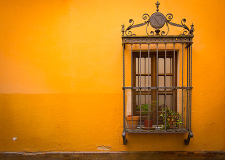 Antique medieval window with rusty iron bars and orange wall in old Santa cruz quarter in Seville, Spain Stock Photo - Budget Royalty-Free & Subscription, Code: 400-09223764