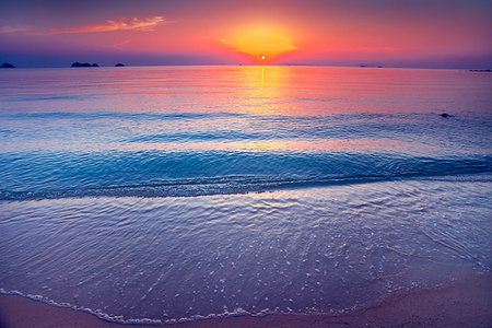 simsearch:400-05372523,k - Wonderful scene the sand shore and calm water surface of the Indian Ocean next to the exotic tropical islands in the kingdom of Thailand. Amazing sunset in the red, orange and gold tints. Stock Photo - Budget Royalty-Free & Subscription, Code: 400-09237586