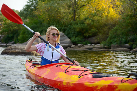 simsearch:400-09237528,k - Young Woman Paddling Kayak on the Beautiful River or Lake among Stones at the Evening Photographie de stock - Aubaine LD & Abonnement, Code: 400-09237797