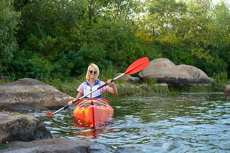 simsearch:400-09237528,k - Young Woman Paddling Kayak on the Beautiful River or Lake among Stones at the Evening Photographie de stock - Aubaine LD & Abonnement, Code: 400-09237798