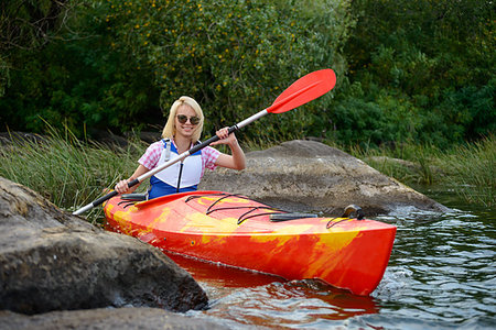 simsearch:400-09237528,k - Young Woman Paddling Kayak on the Beautiful River or Lake among Stones at the Evening Photographie de stock - Aubaine LD & Abonnement, Code: 400-09237801