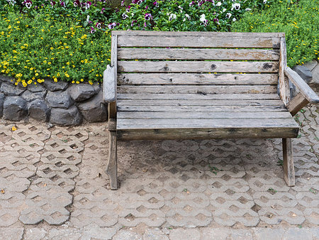 Wooden bench on the brick floor near the flowerbed in the public park. Foto de stock - Royalty-Free Super Valor e Assinatura, Número: 400-09237832