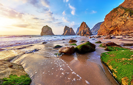 Portugal Ursa Beach at atlantic coast of Atlantic Ocean with rocks and sunset sun waves and foam at sand of coastline picturesque landscape panorama. Stones with green moss in front. Stock Photo - Budget Royalty-Free & Subscription, Code: 400-09238009