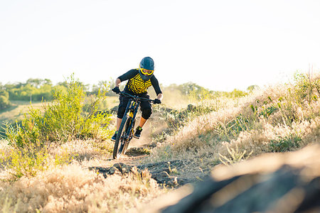 simsearch:400-08673565,k - Professional Cyclist Riding the Downhill Mountain Bike on the Summer Rocky Trail at the Evening. Extreme Sport and Enduro Cycling Concept. Photographie de stock - Aubaine LD & Abonnement, Code: 400-09238165