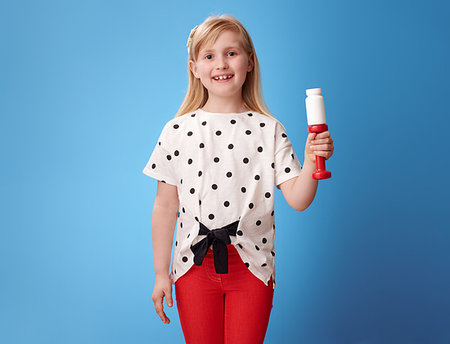 pill bottles girl - happy modern child in red pants showing dumbbell and pills bottle isolated on blue background Stock Photo - Budget Royalty-Free & Subscription, Code: 400-09238190