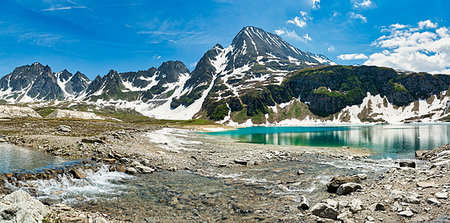 simsearch:400-09237738,k - Lake Castel in Formazza Valley with river in foreground and mountains in backgroud wtih blue sky and clouds Foto de stock - Royalty-Free Super Valor e Assinatura, Número: 400-09238247