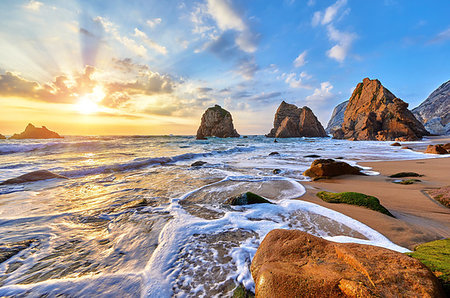 Portugal Ursa Beach at atlantic coast of Atlantic Ocean with rocks and sunset sun waves and foam at sand of coastline picturesque landscape panorama. Stones with green moss in front. Stock Photo - Budget Royalty-Free & Subscription, Code: 400-09238357