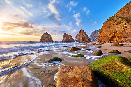 simsearch:400-09237669,k - Portugal Ursa Beach at atlantic coast of Atlantic Ocean with rocks and sunset sun waves and foam at sand of coastline picturesque landscape panorama. Stones with green moss in front. Stock Photo - Budget Royalty-Free & Subscription, Code: 400-09238362