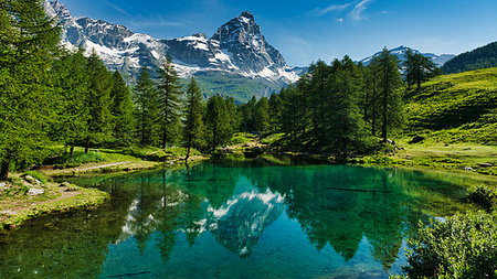 The blue lake and the Matterhorn in a scenic summer landscape with sunny lights seen from Breuil-Cervinia, Aosta Valley - Italy Foto de stock - Royalty-Free Super Valor e Assinatura, Número: 400-09238371