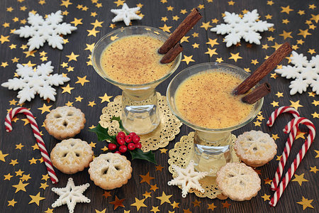 Christmas celebration with eggnog, mince pies, candy canes, star and snowflake decorations with winter holly on rustic oak table background. Festive theme. Photographie de stock - Aubaine LD & Abonnement, Code: 400-09274174