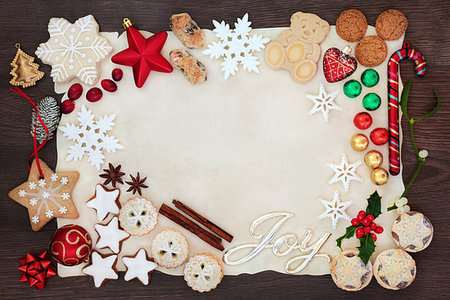 Christmas background border with joy sign including tree decorations, biscuits, cakes, chocolates and winter flora on parchment paper on rustic oak. Flat lay. Stock Photo - Budget Royalty-Free & Subscription, Code: 400-09274172