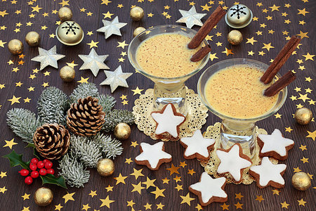 Traditional Christmas eggnog drink with gingerbread biscuits, gold star and bell decorations, foil wrapped chocolate balls with winter flora on rustic oak table background. Photographie de stock - Aubaine LD & Abonnement, Code: 400-09274173