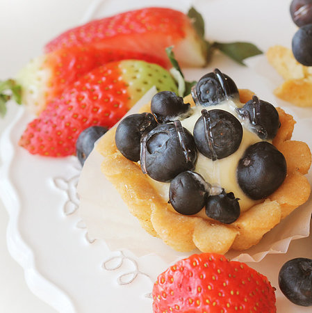 Tartlet with blueberries on white plate . Stockbilder - Microstock & Abonnement, Bildnummer: 400-09274468