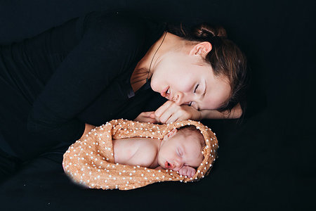 a woman and a newborn baby sleep on a black background. Mother and child Stock Photo - Budget Royalty-Free & Subscription, Code: 400-09274573