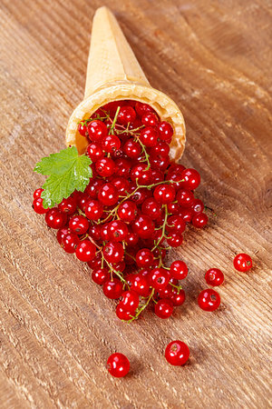 Red currant fruits in ice cream cone on wooden table. Focus on redcurrant. Foto de stock - Super Valor sin royalties y Suscripción, Código: 400-09274989