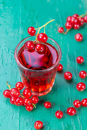 Redcurrant and glass of fruit drink juice on wood table. Focus on redcurrant in glass juice. Foto de stock - Super Valor sin royalties y Suscripción, Código: 400-09274991