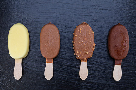 Ice cream on stick covered with chocolate on black stone slate board. Stock Photo - Budget Royalty-Free & Subscription, Code: 400-09275076