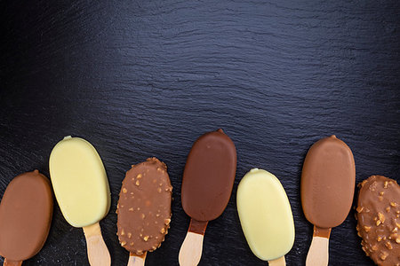 simsearch:400-06854949,k - Ice cream on stick covered with chocolate on black stone slate board. Stockbilder - Microstock & Abonnement, Bildnummer: 400-09275079