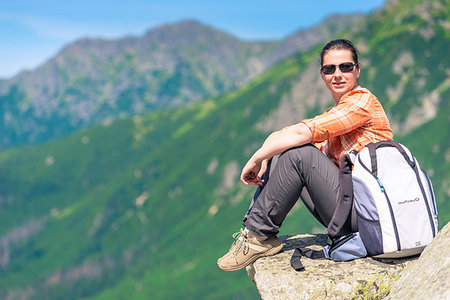 simsearch:400-08626705,k - active tourist sits on a rock in the mountains with a backpack, relax with a view of the mountains Foto de stock - Super Valor sin royalties y Suscripción, Código: 400-09275351
