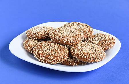 Oatmeal cookies with sesame seeds in a white dish on a violet background. Close up Stock Photo - Budget Royalty-Free & Subscription, Code: 400-09275385