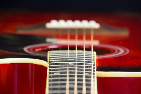 simsearch:400-05352838,k - Acoustic red guitar lies on the table in the background with a copy of the hand space, playing acoustic guitar, close-up of fretboard and strings, instrument deck, Wallpaper Photographie de stock - Aubaine LD & Abonnement, Code: 400-09275413