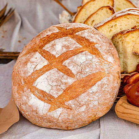 simsearch:400-07996450,k - delicious fresh baked rustic bread round bun rolled up with flour on the background of chopped pieces of rustic design culinary Foto de stock - Royalty-Free Super Valor e Assinatura, Número: 400-09275554