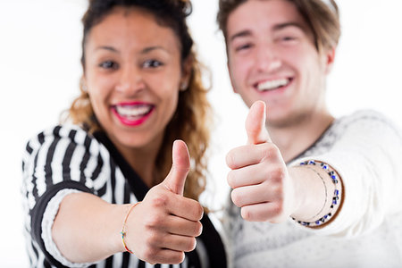 perfect timing - Young happy woman with smiling man giving thumbs up in close up against white background Stock Photo - Budget Royalty-Free & Subscription, Code: 400-09273441