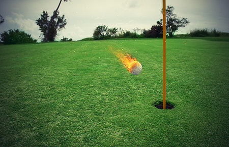 Fiery golf ball near the hole in a green grass field Stock Photo - Budget Royalty-Free & Subscription, Code: 400-09273597