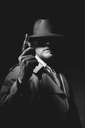 simsearch:400-07817846,k - Undercover agent holding a pistol in the dark, 1950s noir film character Fotografie stock - Microstock e Abbonamento, Codice: 400-09273838
