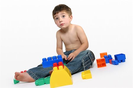 simsearch:693-06379407,k - Young boy sits amongst colourful generic building blocks. Stock Photo - Budget Royalty-Free & Subscription, Code: 400-03908600