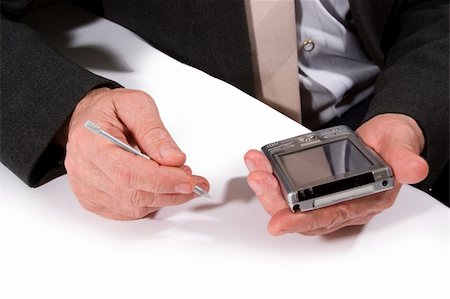 man's hands holding pocket pc and pen on white table Stock Photo - Budget Royalty-Free & Subscription, Code: 400-03914043