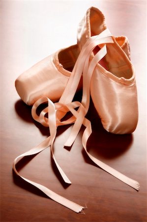 Pink satin ballet shoes on dark floor in slight soft focus Photographie de stock - Aubaine LD & Abonnement, Code: 400-03915325