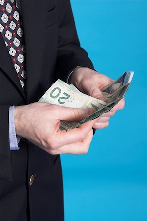 businessman and money over blue background Stock Photo - Budget Royalty-Free & Subscription, Code: 400-03916330
