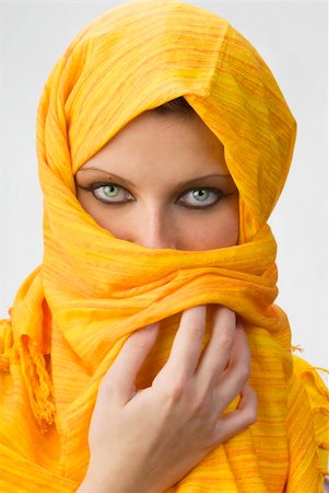 attactive and strong eyes behind an orange scarf used like a burka Stock Photo - Budget Royalty-Free & Subscription, Code: 400-03918906