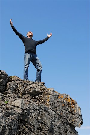 simsearch:400-05147336,k - A man standing on a cliff with his arms raised to the blue sky Foto de stock - Super Valor sin royalties y Suscripción, Código: 400-03919512